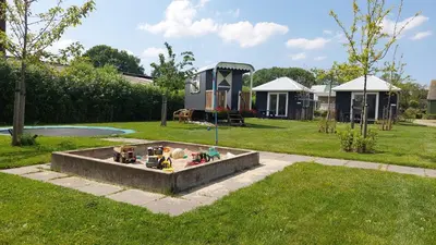 a tiny house in a yard with a backyard at Recreatie aan de Vecht, chalet 3, genieten van de rust en ruimte en toch dichtbij de stad in Weesp