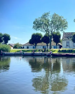 a group of boats are docked on a river at Recreatie aan de Vecht, chalet 3, genieten van de rust en ruimte en toch dichtbij de stad in Weesp