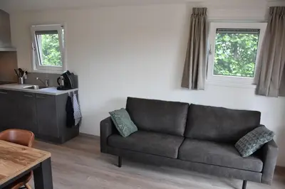 a living room with a couch and a sink at Recreatie aan de Vecht, chalet 3, genieten van de rust en ruimte en toch dichtbij de stad in Weesp