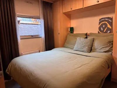 a bedroom with a large bed with a window at Vlinderzicht in Koedijk