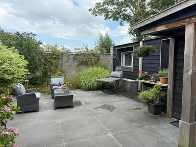 a patio with two chairs and a table at Vlinderzicht in Koedijk