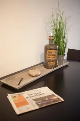 a bottle of whiskey sitting on a table with a magazine at Apartment 4G in Amersfoort