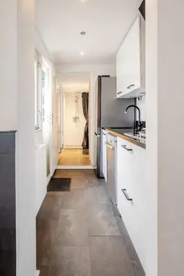 a kitchen with white cabinets and a tile floor at Large Family House Alkmaar in Alkmaar