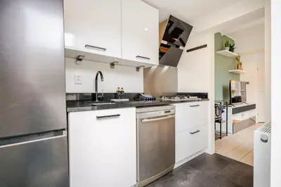 a kitchen with white cabinets and a stainless steel refrigerator at Large Family House Alkmaar in Alkmaar