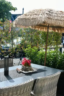 a table with a basket of flowers and an umbrella at Costa C en E in Noordwijk