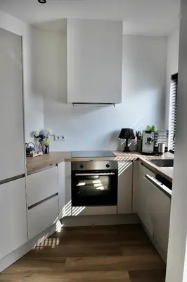 a kitchen with white cabinets and a black oven at Costa C en E in Noordwijk