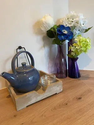 a table with vases and a tea pot and flowers at Costa C en E in Noordwijk