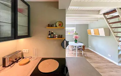 a kitchen with a staircase and a table in a room at Cozy Home In Bergen Aan Zee With Wifi in Bergen aan Zee