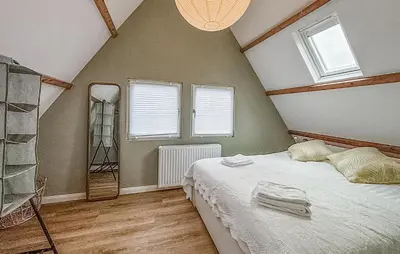 a bedroom with a bed and a ladder in a room at Cozy Home In Bergen Aan Zee With Wifi in Bergen aan Zee