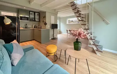 a living room with a blue couch and a table at Cozy Home In Bergen Aan Zee With Wifi in Bergen aan Zee