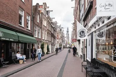 a city street with people walking down the street at Panoramic canalview apartment in Amsterdam