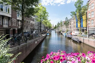 a canal in a city with buildings and flowers at Panoramic canalview apartment in Amsterdam