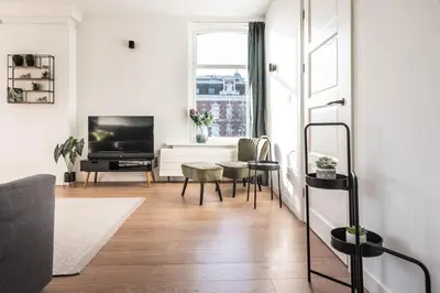 a living room with a television and a table at Panoramic canalview apartment in Amsterdam