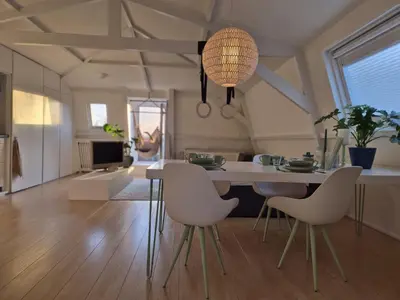 a kitchen and living room with a table and chairs at Appartement Zijlweg in Haarlem