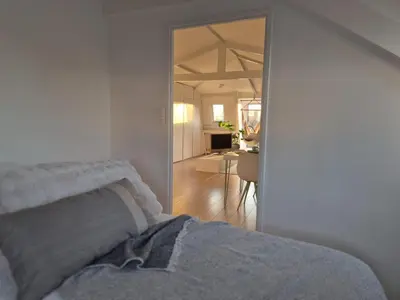 a bedroom with a bed and a door leading to a kitchen at Appartement Zijlweg in Haarlem
