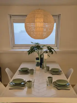a dining room table with a chandelier above it at Appartement Zijlweg in Haarlem