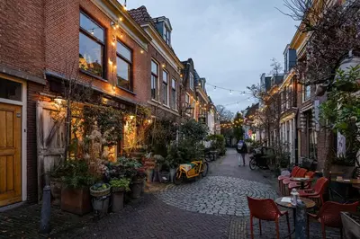 a narrow street with tables and chairs and buildings at Appartement Zijlweg in Haarlem