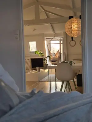 a bedroom with a table and chairs and a living room at Appartement Zijlweg in Haarlem