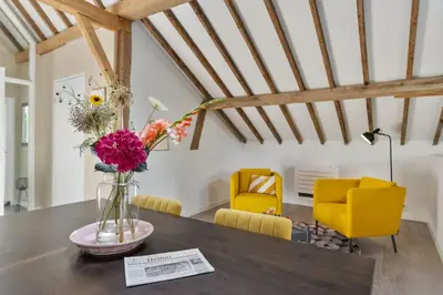 a vase of flowers on a table in a room at Boerderijwoning 't Trogje in Heiloo