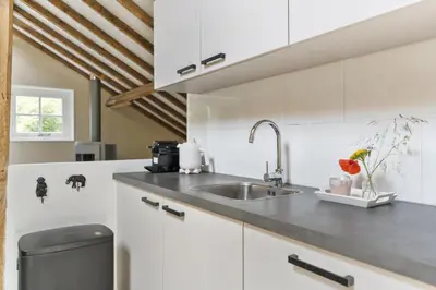 a kitchen with white cabinets and a sink at Boerderijwoning 't Trogje in Heiloo