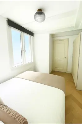 a white bedroom with a bed and a window at Canal House The Manor in Amsterdam