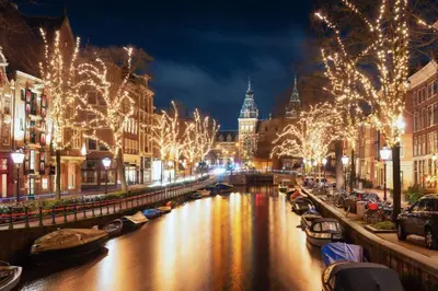 a city at night with christmas lights and a canal at Canal House The Manor in Amsterdam