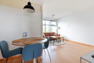 a living room with a table and chairs at De Schelp 66, Free parking in Zandvoort