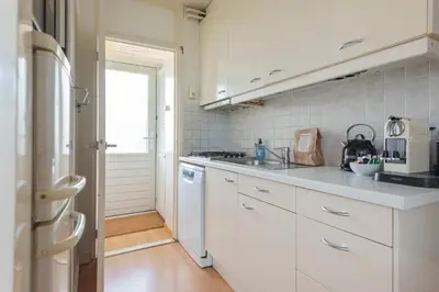 a kitchen with white cabinets and a stove top oven at De Schelp 66, Free parking in Zandvoort