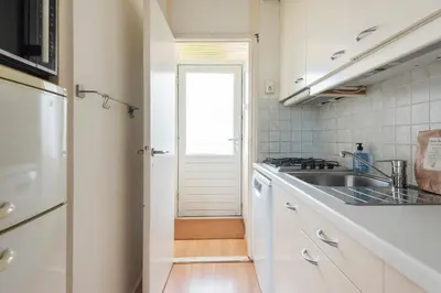 a white kitchen with a sink and a stove at De Schelp 66, Free parking in Zandvoort