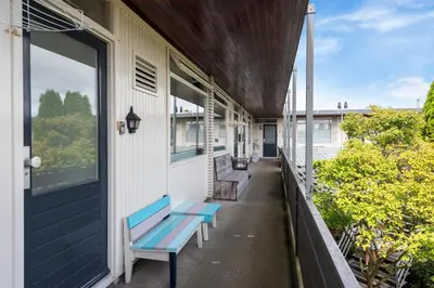 a porch with two blue benches on a house at De Schelp 66, Free parking in Zandvoort
