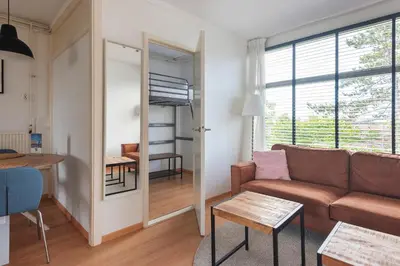 a living room with a couch and a table at De Schelp 66, Free parking in Zandvoort