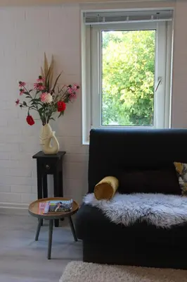 a living room with a black couch and a window at Viva la Vida in Bergen