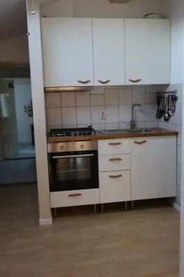 a kitchen with white cabinets and a stove at Viva la Vida in Bergen