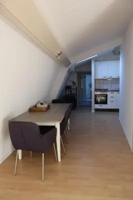 a dining room with a table and chairs and a kitchen at Viva la Vida in Bergen