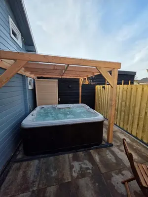 a hot tub under a pergola on a patio at leuke gezellige blokhut in Vijfhuizen