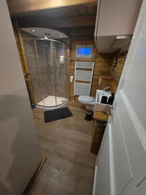 a bathroom with a glass shower and a toilet at leuke gezellige blokhut in Vijfhuizen