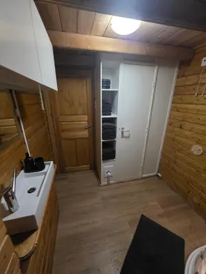 a bathroom with a white sink and a door at leuke gezellige blokhut in Vijfhuizen