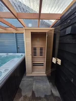 a jacuzzi tub in a room with a wooden ceiling at leuke gezellige blokhut in Vijfhuizen