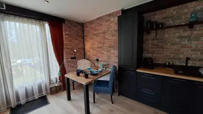 a kitchen with a table and a brick wall at B&B Aquamarijn Katwijk in Katwijk aan Zee