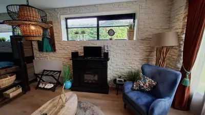 a living room with a blue chair and a fireplace at B&B Aquamarijn Katwijk in Katwijk aan Zee