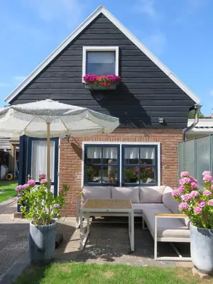 a house with a couch and a table and an umbrella at Sonne in Egmond aan Zee