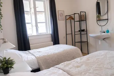 a bedroom with two beds and a sink and a window at T Pronkhuis in Egmond aan Zee