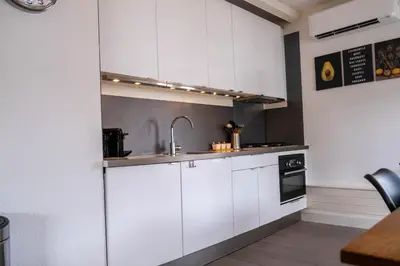 a kitchen with white cabinets and a sink at T Pronkhuis in Egmond aan Zee