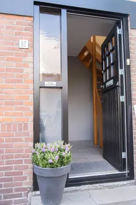 a pot of flowers on the side of a building at T Pronkhuis in Egmond aan Zee