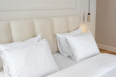 a bed with white pillows and a headboard at Boutique hotel Novi in Zandvoort