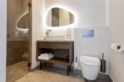 a bathroom with a toilet and a sink and a mirror at Boutique hotel Novi in Zandvoort