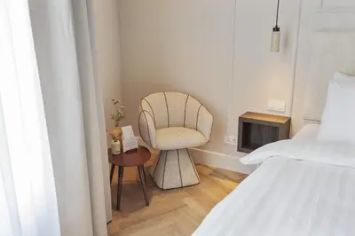 a bedroom with a chair and a table and a bed at Boutique hotel Novi in Zandvoort