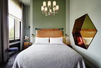 a bedroom with a bed and a chandelier at The Hoxton, Amsterdam in Amsterdam