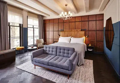 a bedroom with a bed and a couch at The Hoxton, Amsterdam in Amsterdam