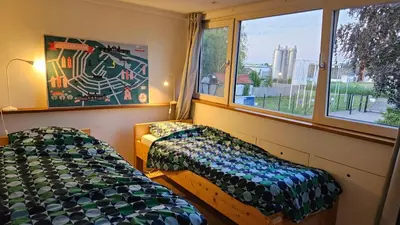 a bedroom with two beds and a window at Amsterdam ZaanseSchans House in Krommenie